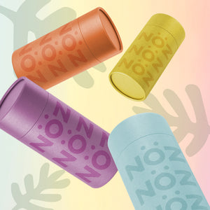 Four (4) colorful Nözscreen sunscreen canisters falling in front of a colorful background.